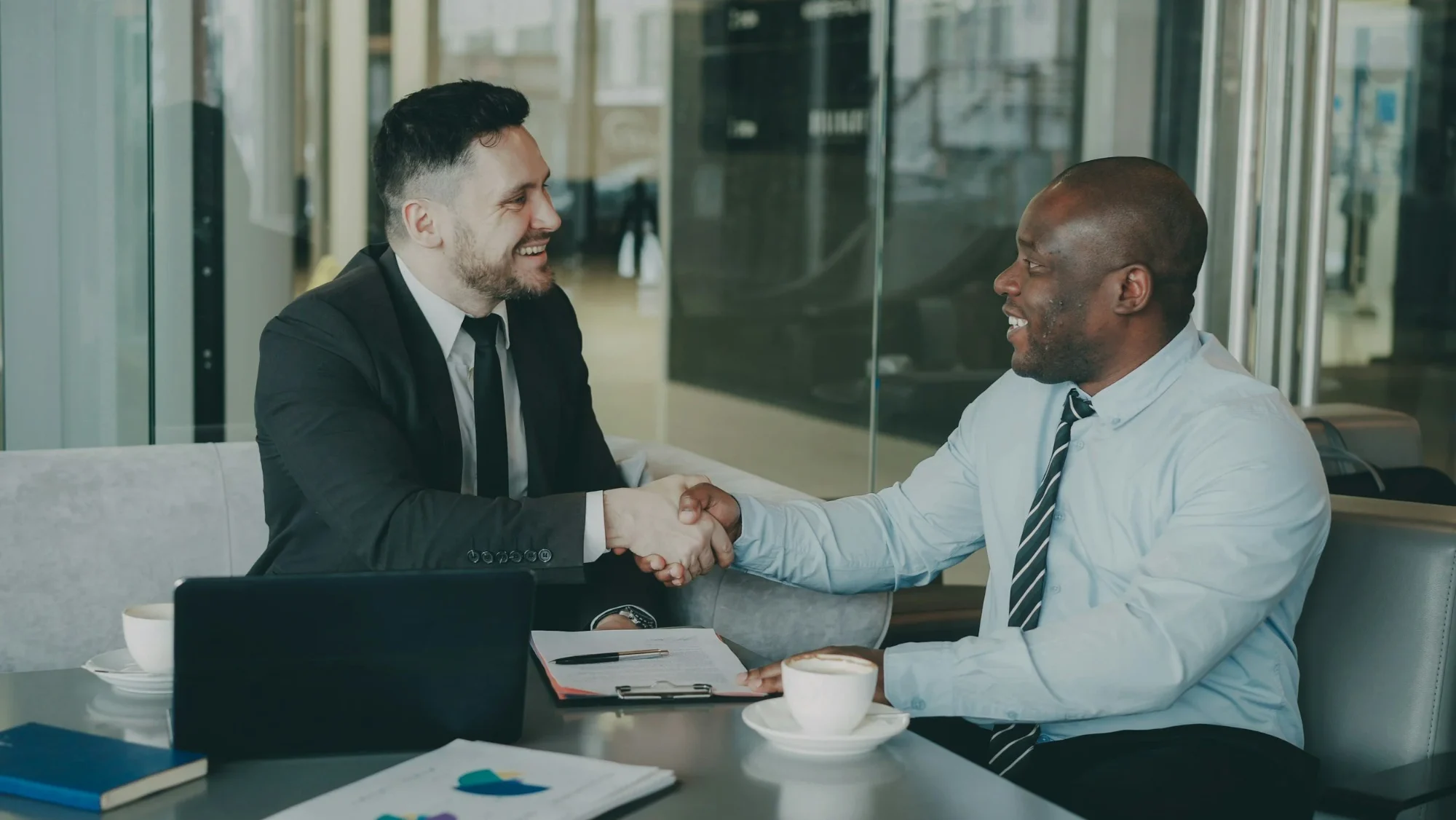 Two professionals shaking hands across a table